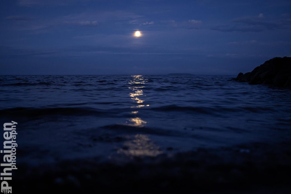 Kuutamo ja järvenpinnasta heijastuva kuunsilta Oulujärvellä illalla.